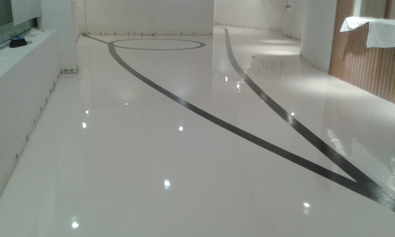 Pavimento de resina blanco con líneas decorativas en local comercial